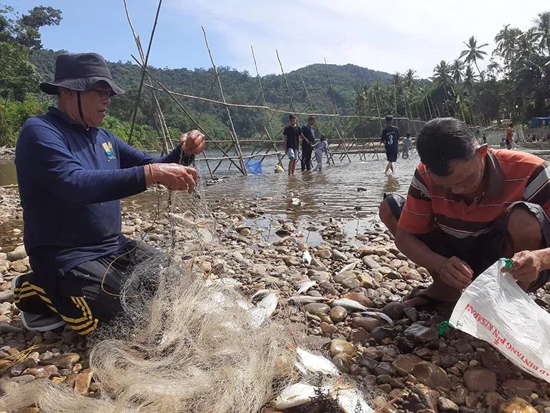 Masyarakat melepaskan ikan dari jaring hasil tangkapan di lubuk larangan. Foto: Suryadi/Mongabay Indonesia